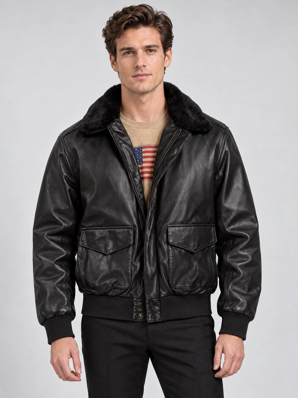 Front studio view of a model wearing a Black Leather Bomber Jacket with a plush collar, zip front, and flap pockets.