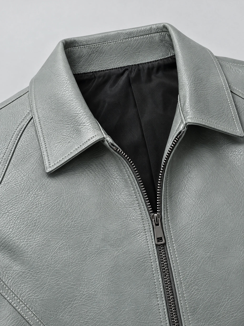 Close-up of the Gray leather bomber jacket’s wide collar, textured PU leather, stitched seams, and front zipper.