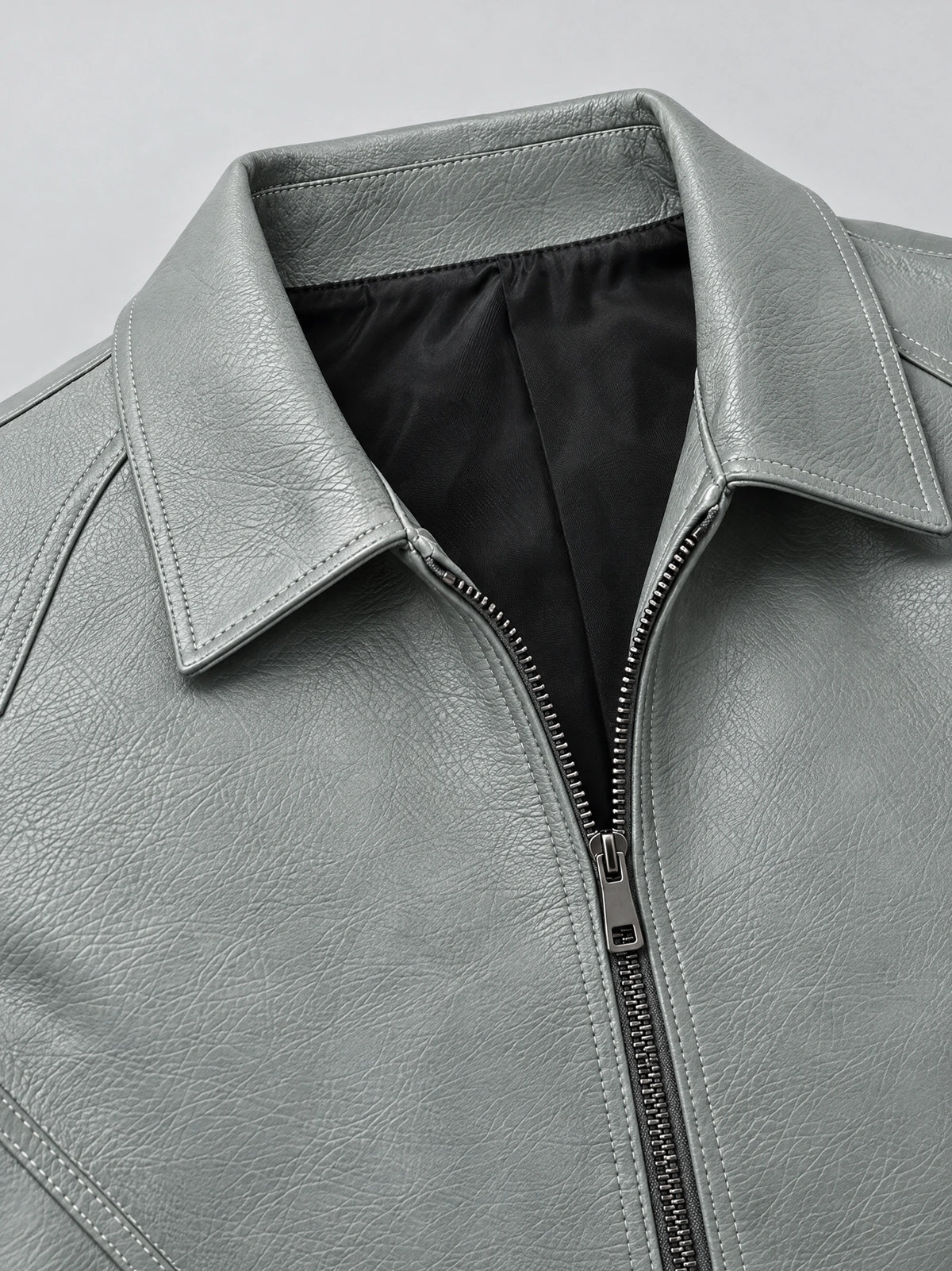 Close-up of the Gray leather bomber jacket’s wide collar, textured PU leather, stitched seams, and front zipper.