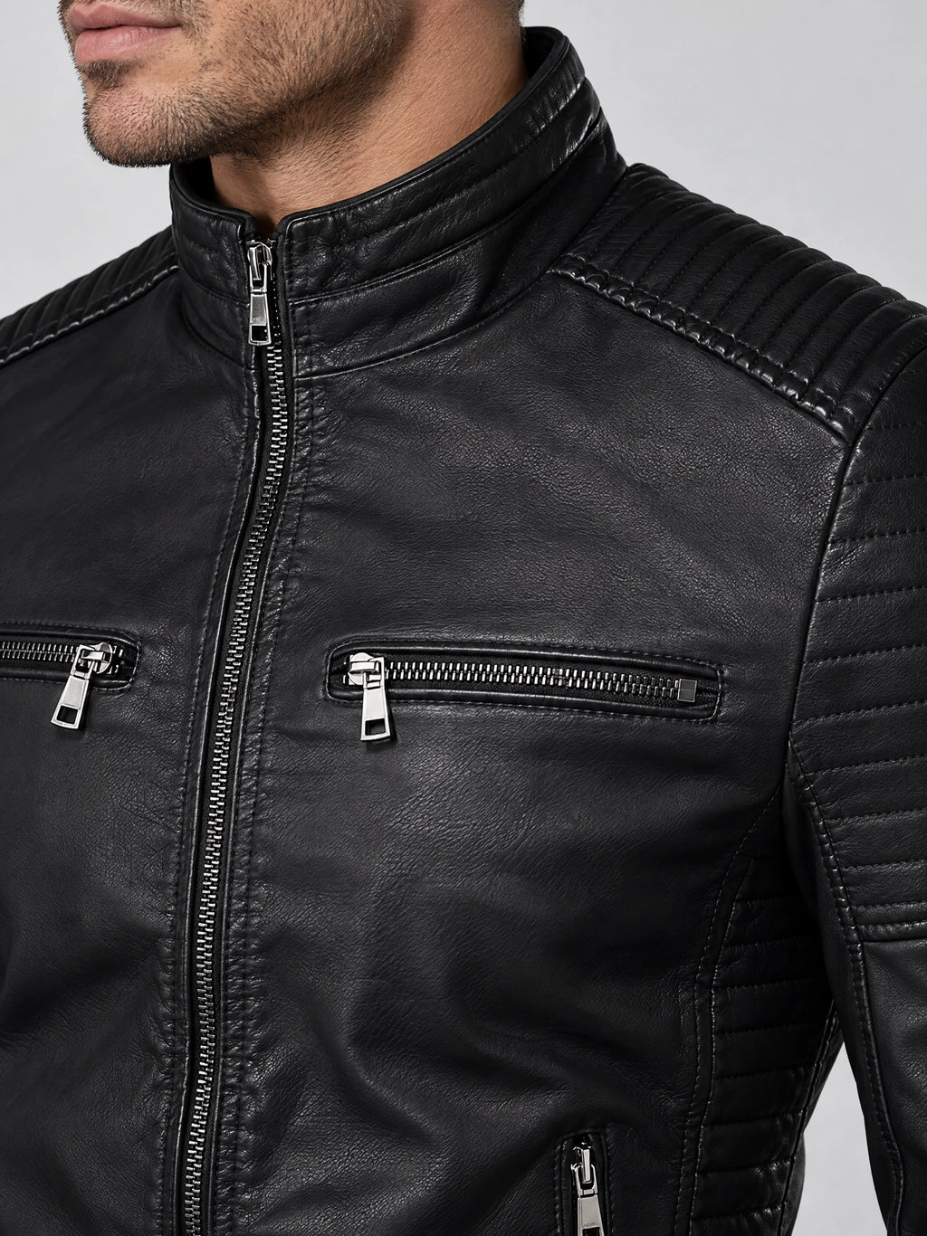 Close-up of a Black men's Leather Fall Jacket showing the stand collar, front zipper, chest zipper pockets, and ribbed shoulder panels.