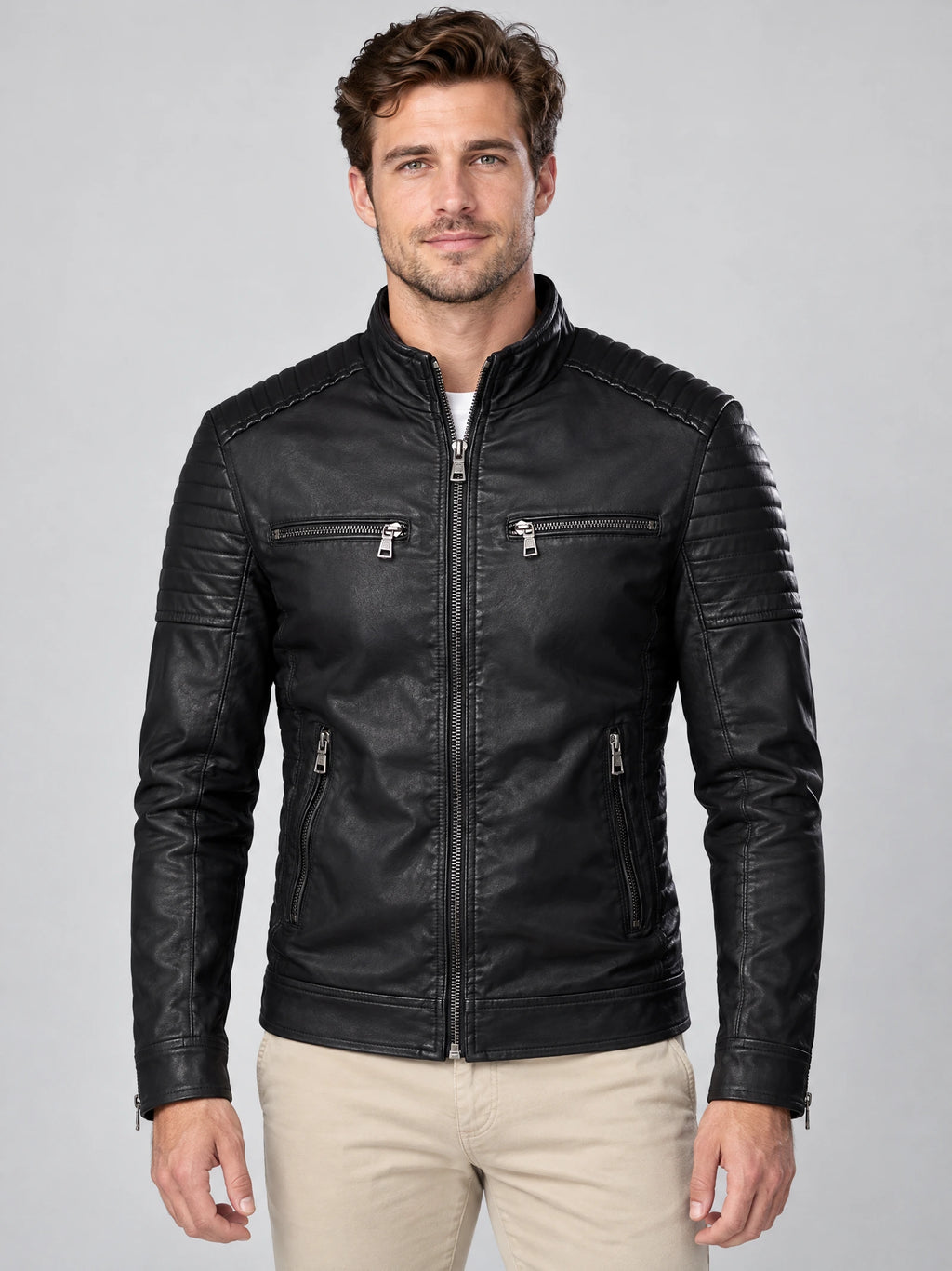 Front studio view of a model wearing a Black Leather Fall Jacket with a stand collar, quilted shoulders, and zippered chest and side pockets.