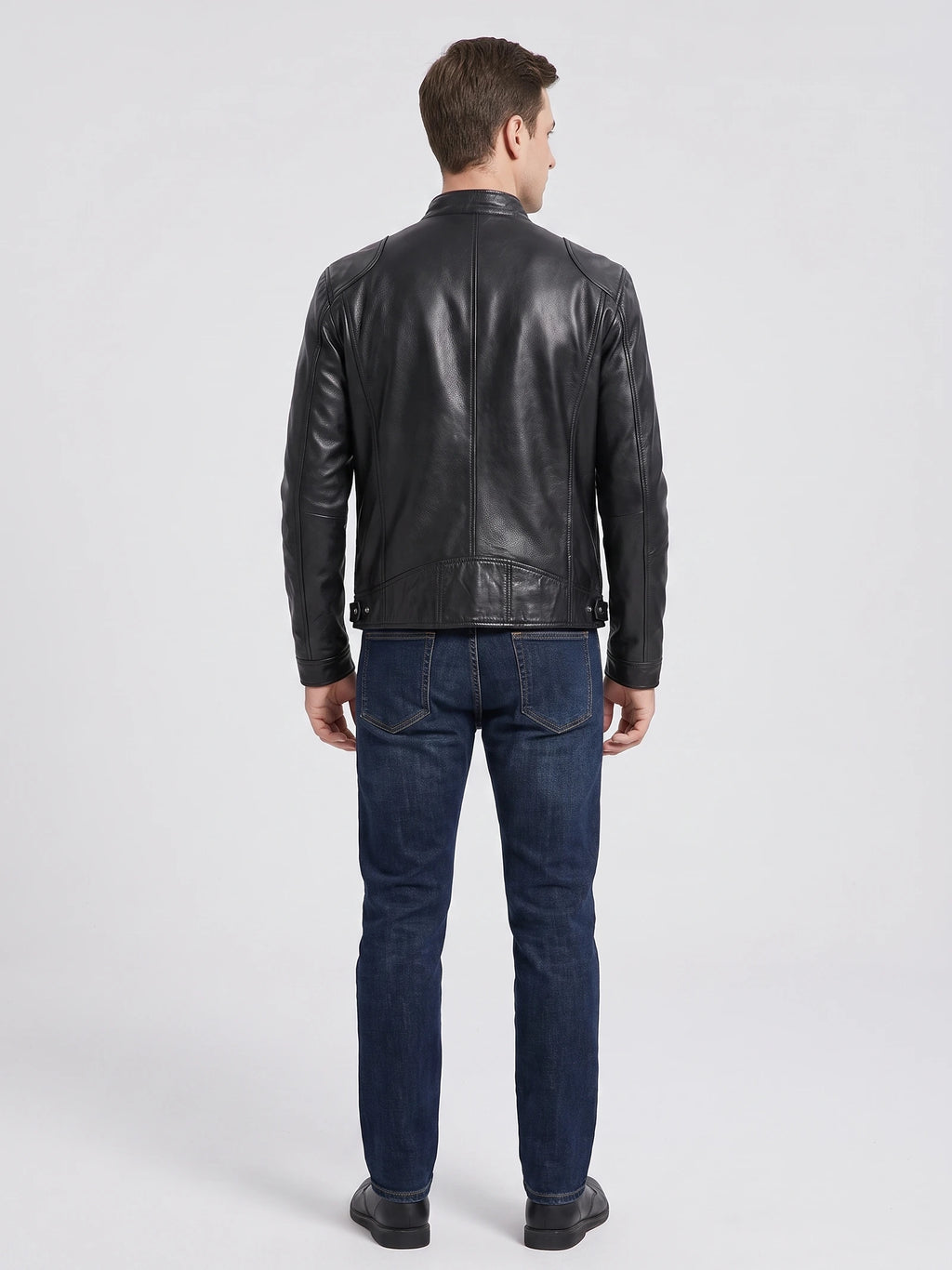 Rear studio view of a model wearing a Black Men's Leather Jacket with paneled back stitching and adjustable side tabs.
