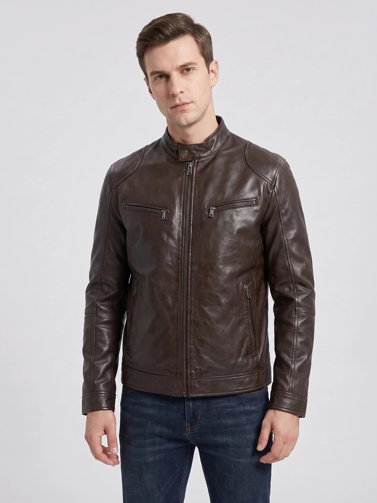 Front studio view of a model wearing a Brown men's leather jacket with a stand collar, zip front, and chest pockets.