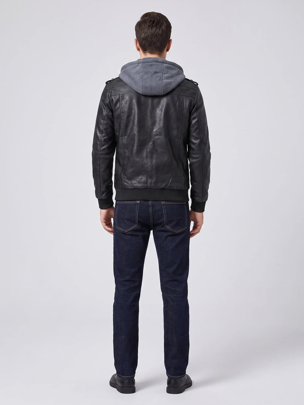 Rear studio view of a model wearing a Black mens leather jacket with a hood, shoulder tabs, and ribbed hem and cuffs.