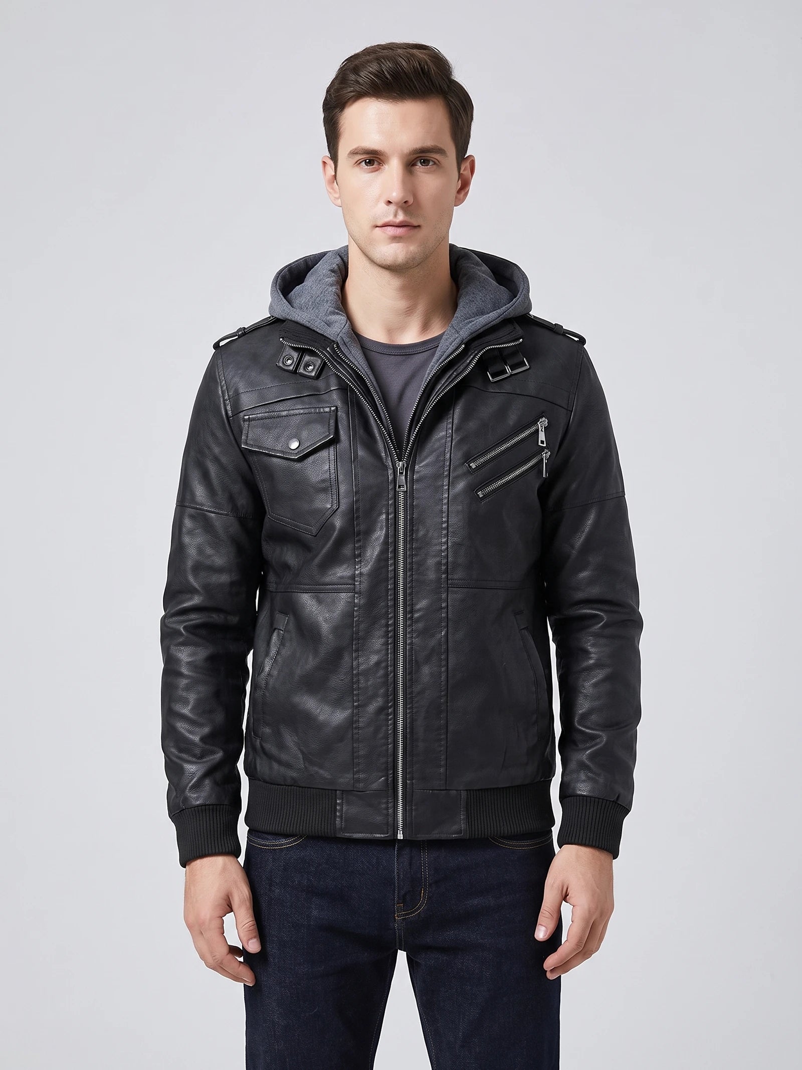 Front studio view of a model wearing a Black mens leather jacket with a hooded insert, zip pockets, and ribbed cuffs.
