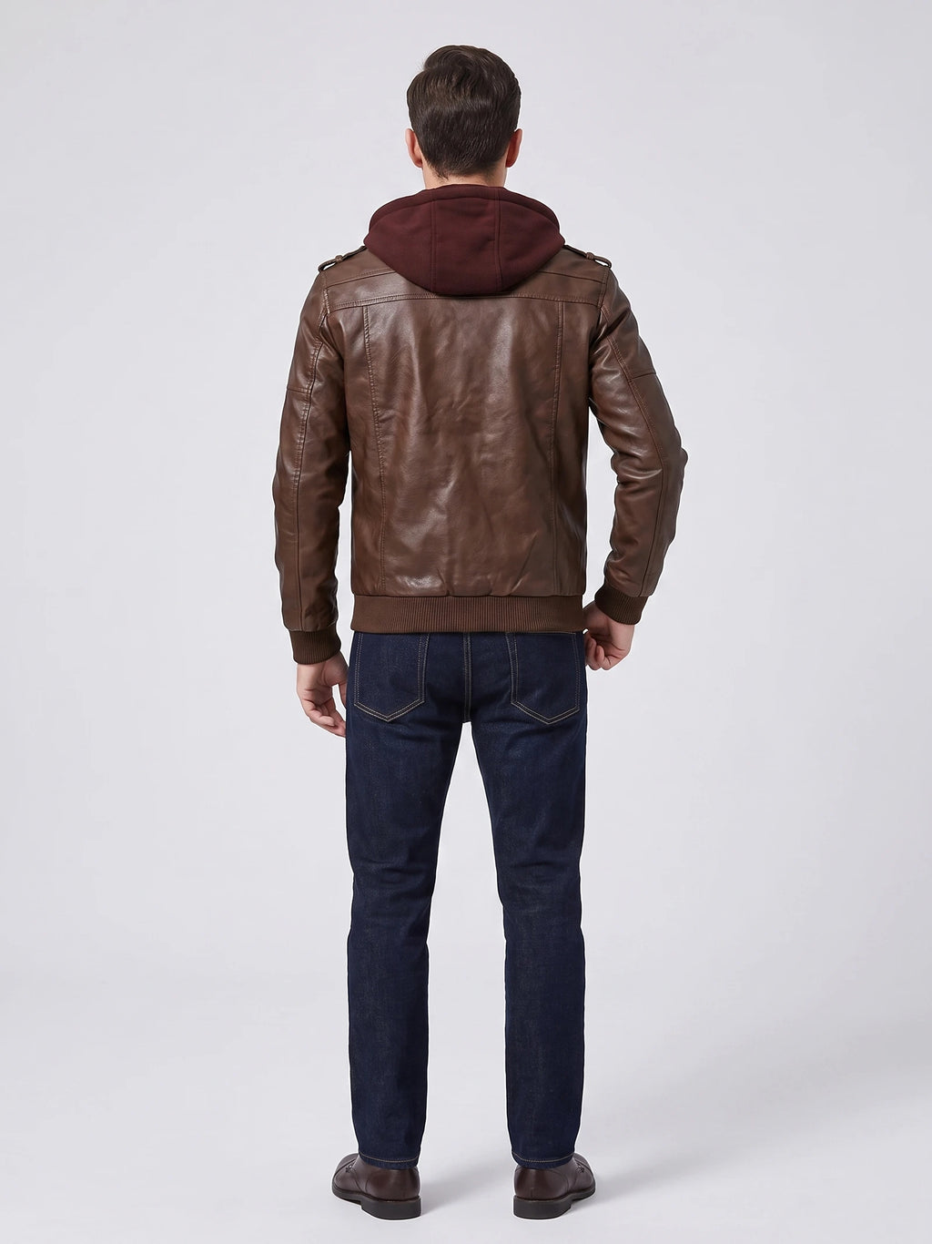 Rear view of a model wearing a Brown mens leather jacket with a hood, shoulder tabs, and ribbed cuffs and hem.