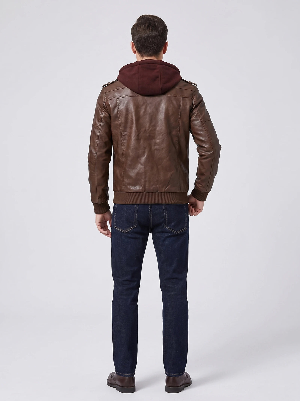 Rear view of a model wearing a Brown mens leather jacket with a hood, shoulder tabs, and ribbed cuffs and hem.