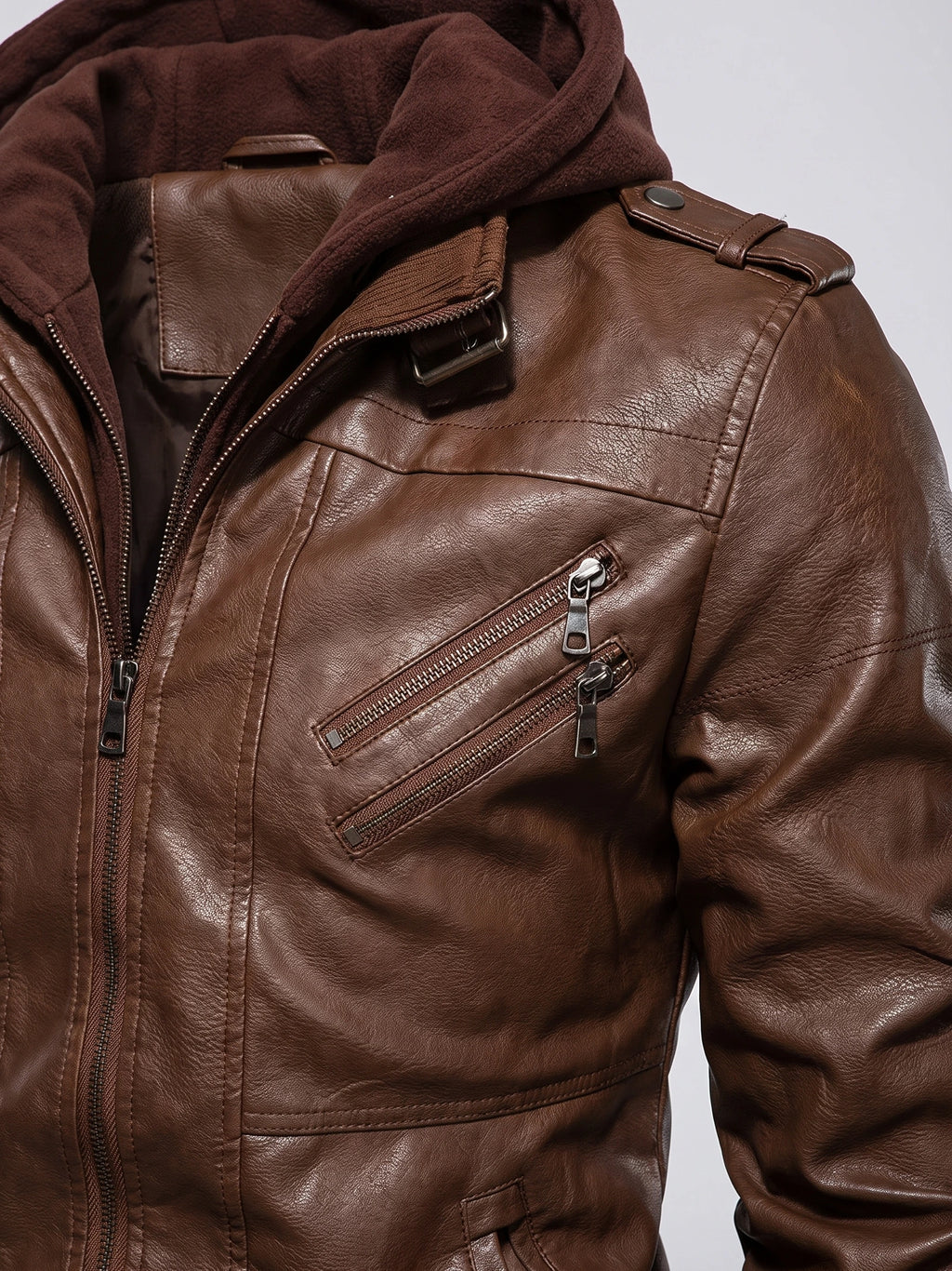 Close-up of a Brown mens leather jacket with a soft collar, shoulder tab, textured finish, and dual zip chest pockets.