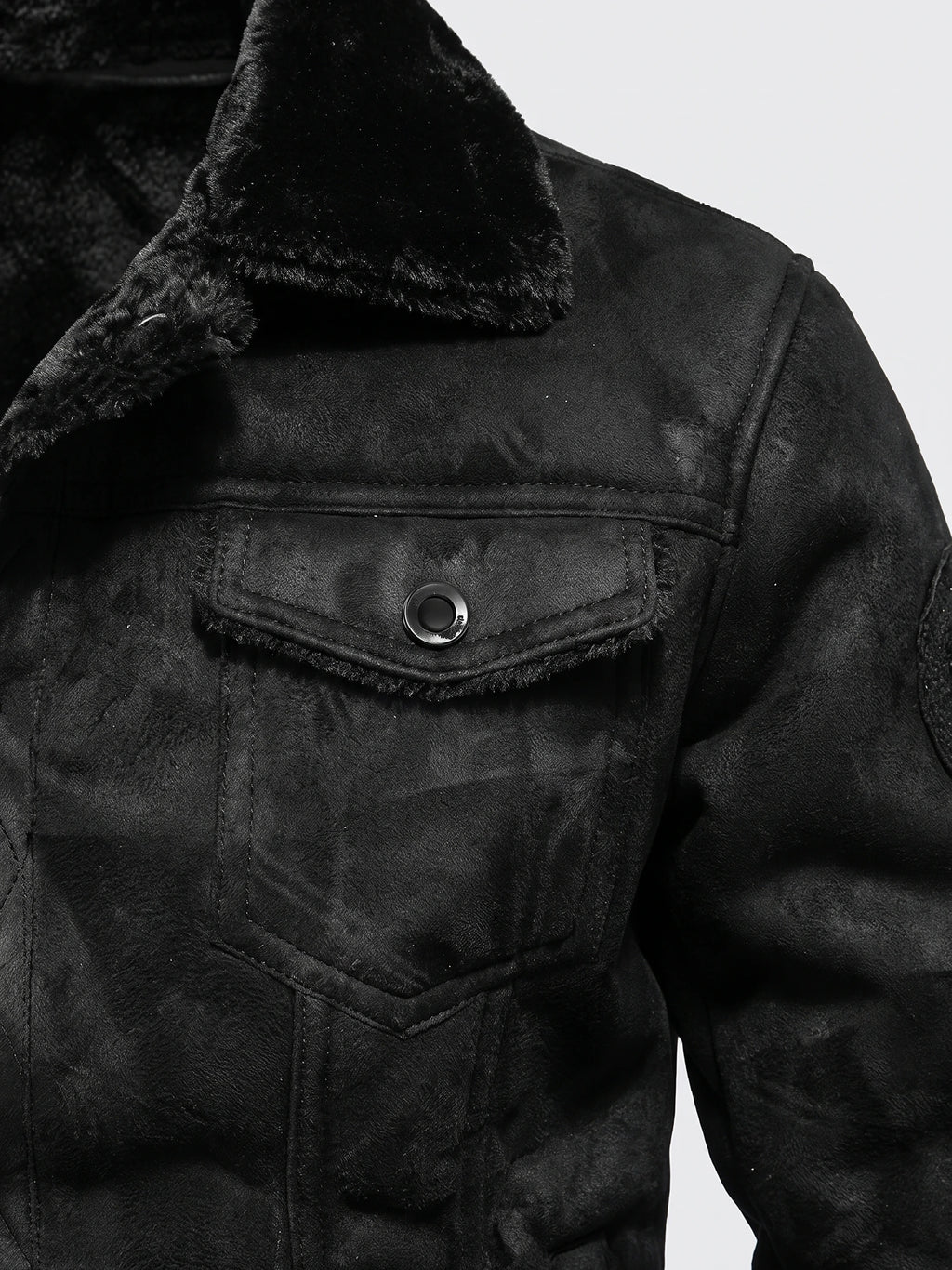Close-up of a Black men’s leather jacket with a fleece-lined collar and buttoned flap chest pocket.