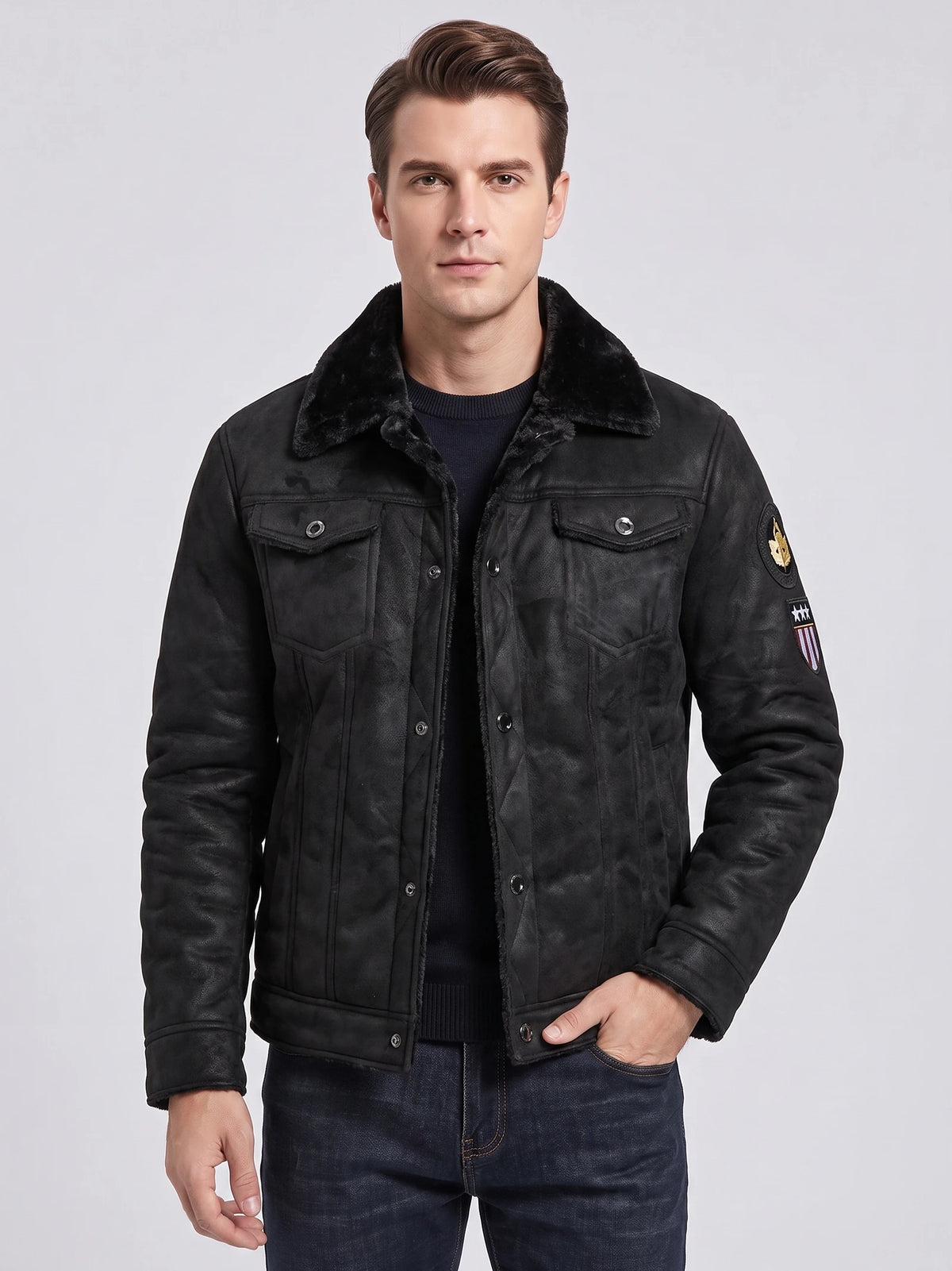 Front studio view of a model wearing a Black leather jacket with a plush collar, snap-button chest pockets, and sleeve patches.