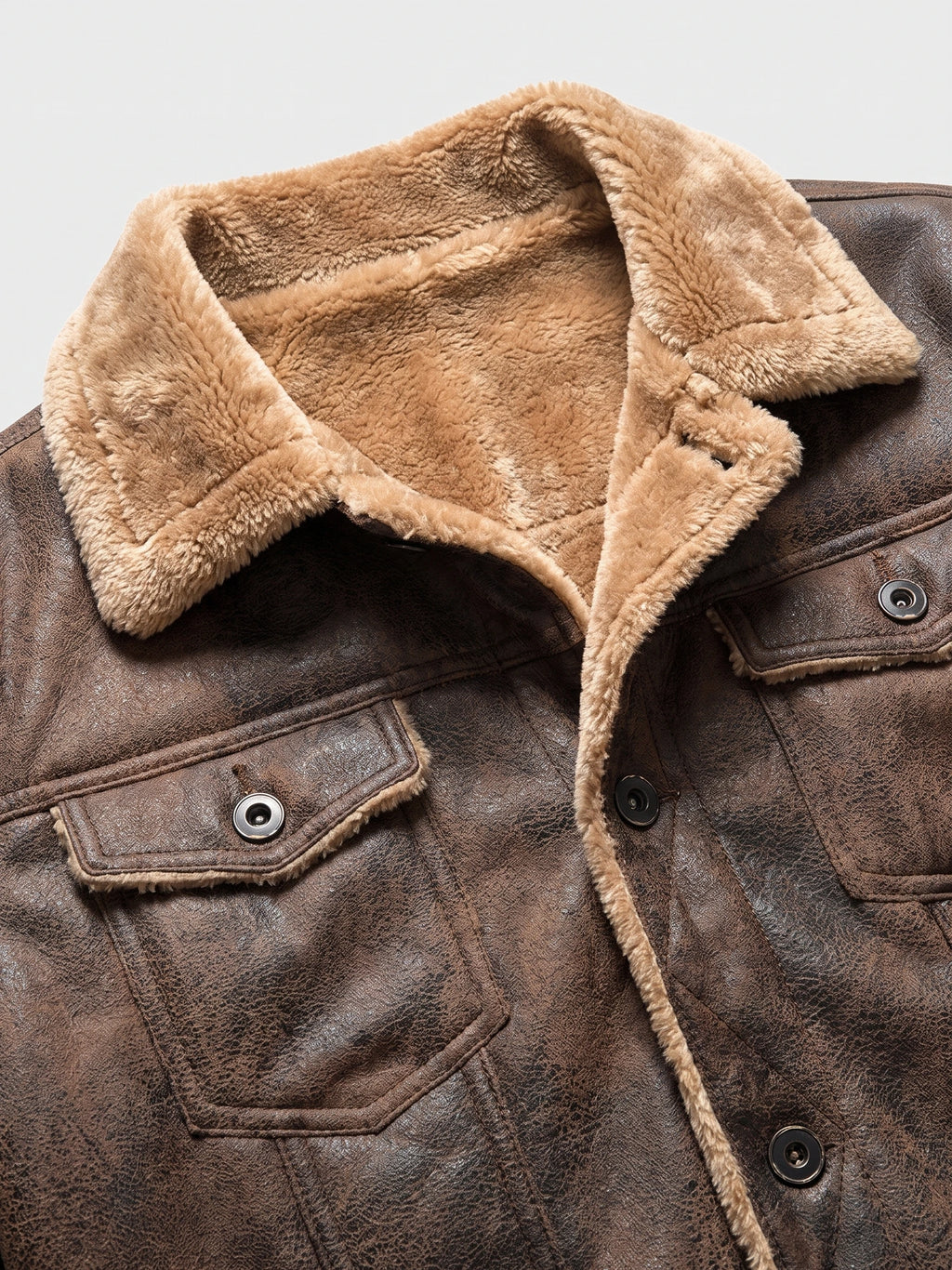 Close-up of the Brown leather jacket’s plush fleece-lined collar, snap-button tabs, and textured outer finish.
