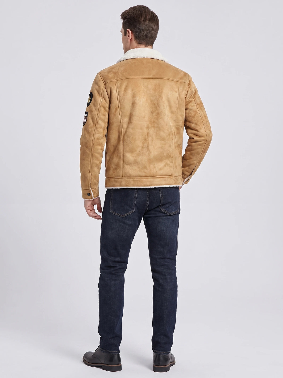 Rear view of a model wearing a Khaki leather jacket with a fleece-lined collar, back seam detailing, and sleeve patches.