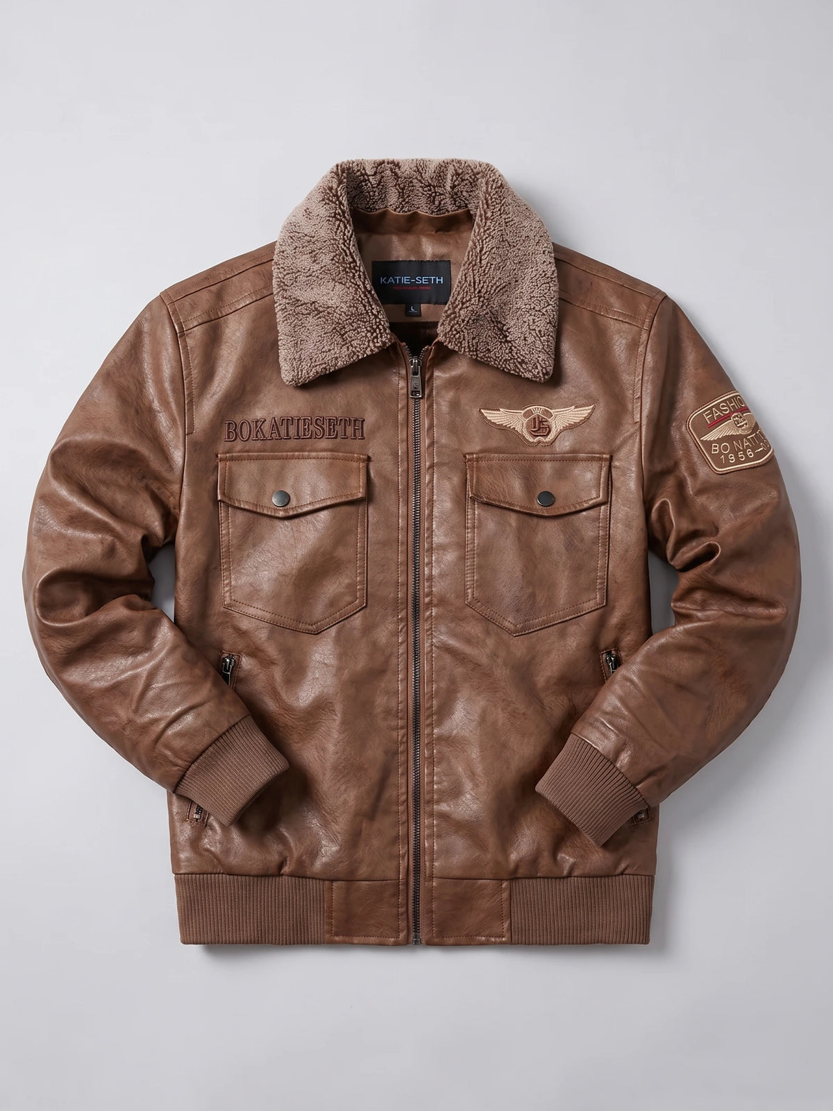Brown Leather Jacket laid flat with a textured fur collar, zip front, flap chest pockets, embroidered patches, and ribbed cuffs and hem.