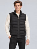 Front studio view of a model wearing a Black lightweight puffer vest with a stand collar, zip front, and quilted panels.