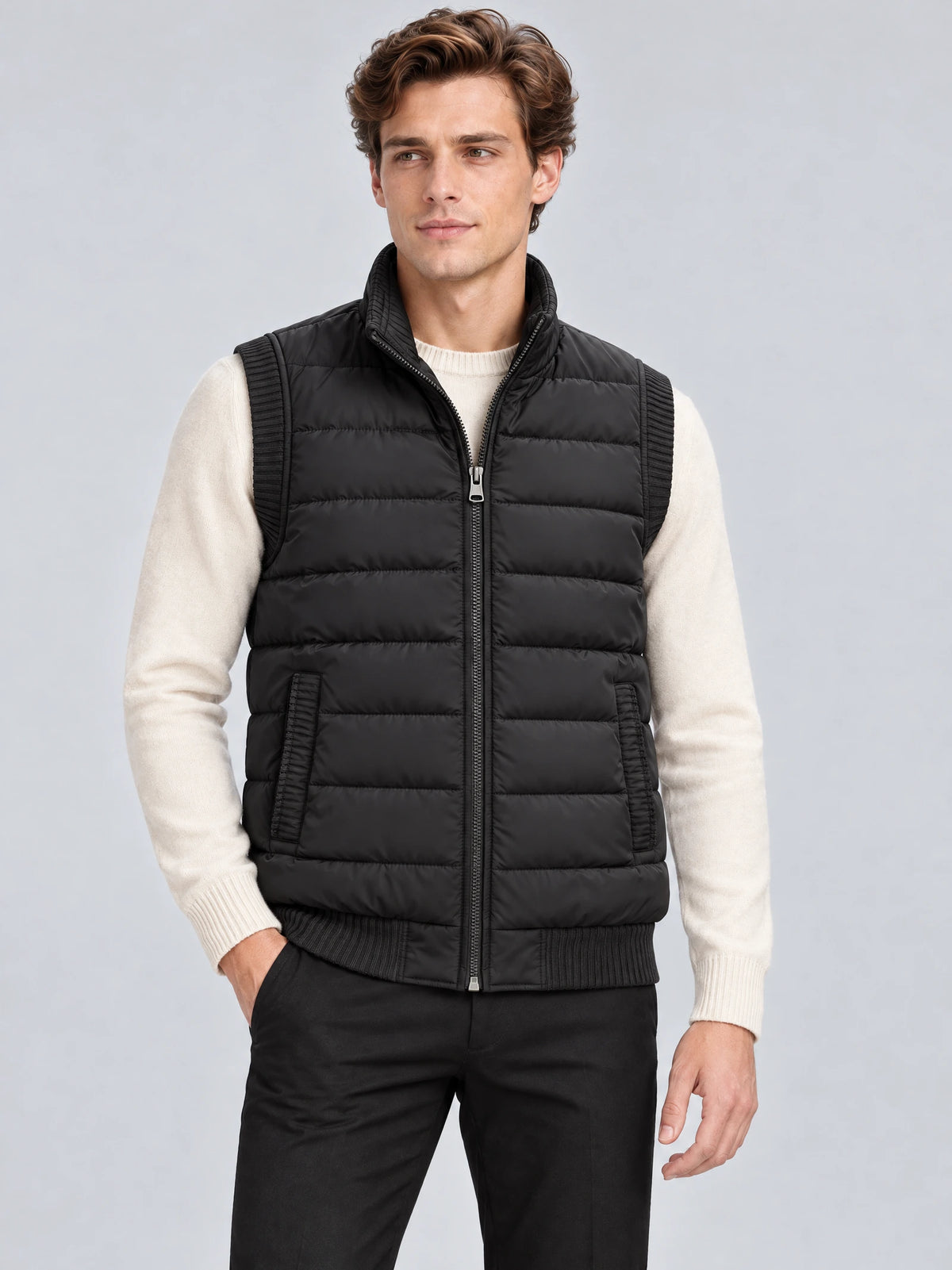 Front studio view of a model wearing a Black lightweight puffer vest with a stand collar, zip front, and quilted panels.