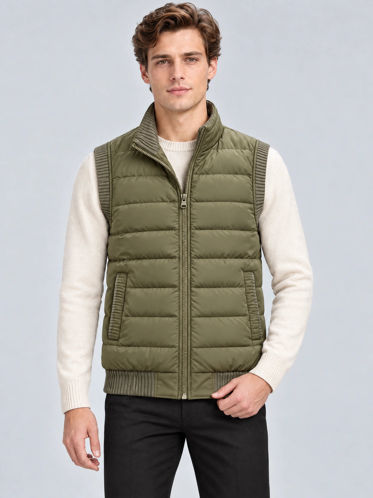 Front studio view of a model wearing a Green lightweight puffer vest with quilted panels, zip front, ribbed trim, and side pockets.