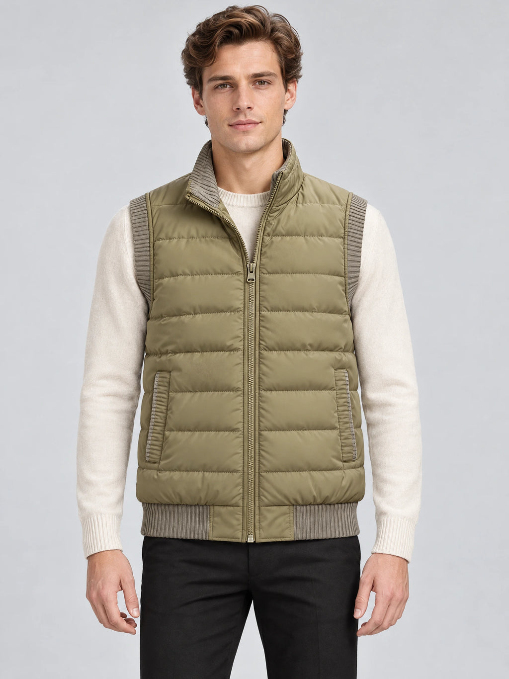 Front studio view of a model wearing a Khaki lightweight puffer vest with a zip front, quilted panels, ribbed trim, and side pockets.