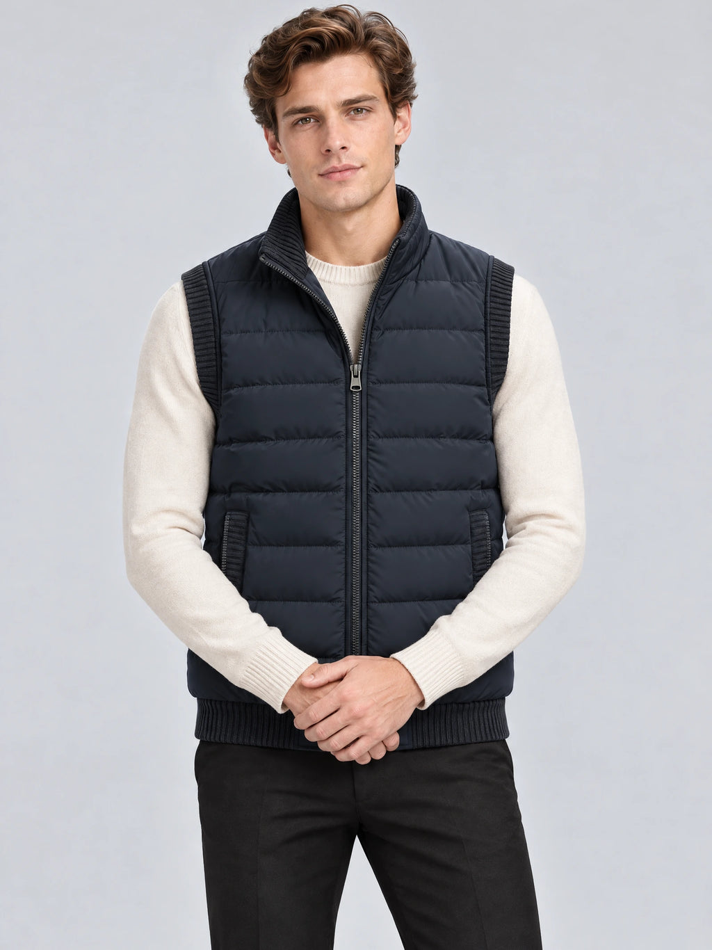 Front studio view of a model wearing a Navy lightweight puffer vest with a zip-front, quilted panels, and ribbed trim.