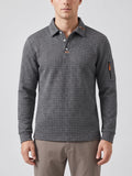 Front studio view of a model wearing a Gray long sleeve polo with a textured grid knit, button placket, and sleeve zip pocket.