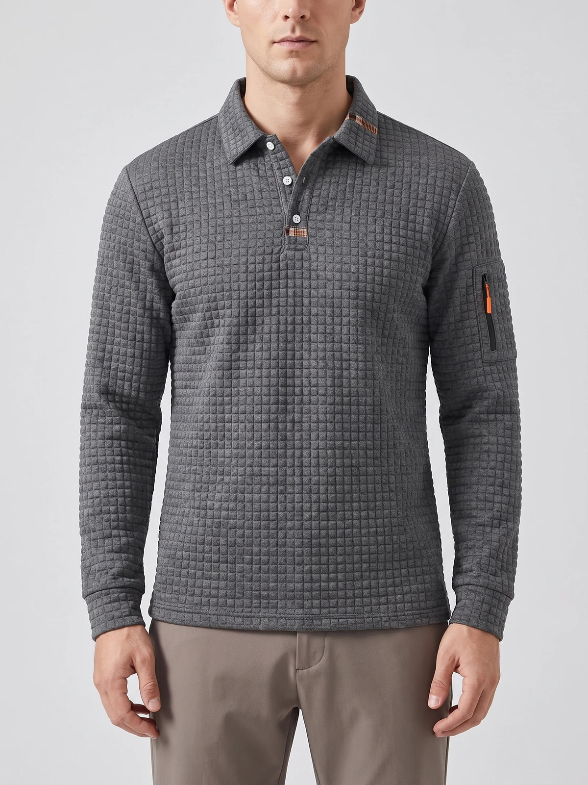 Front studio view of a model wearing a Gray long sleeve polo with a textured grid knit, button placket, and sleeve zip pocket.