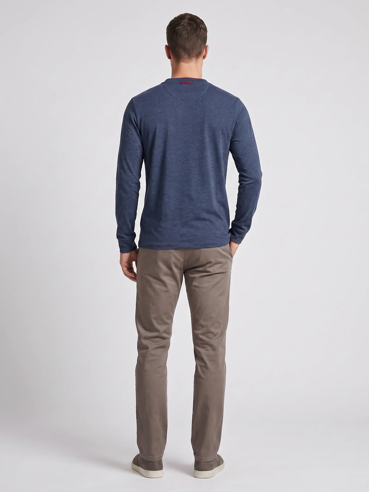 Rear studio view of a model wearing a Navy cotton long sleeve Henley shirt.