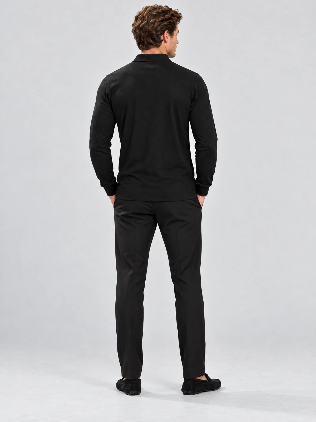 Rear studio view of a model wearing a Black Long Sleeve Polo with a smooth back and long sleeves.