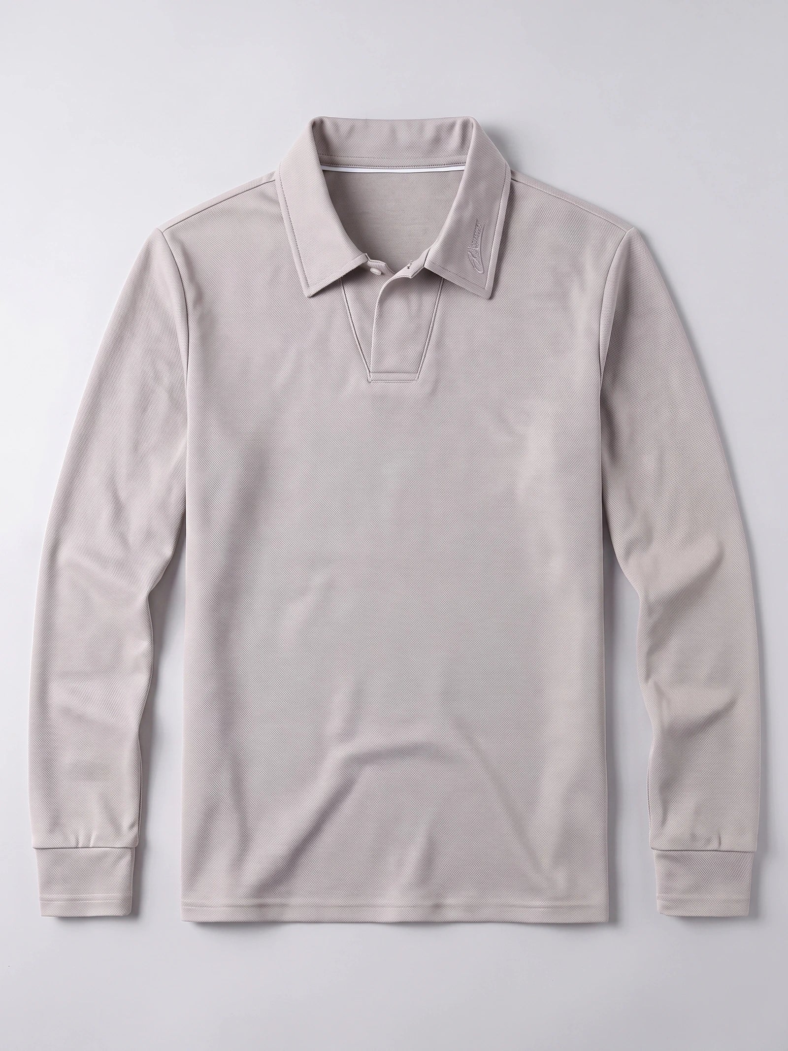 Beige men's long sleeve polo laid flat, featuring a textured knit, embroidered turn-down collar, and button placket.