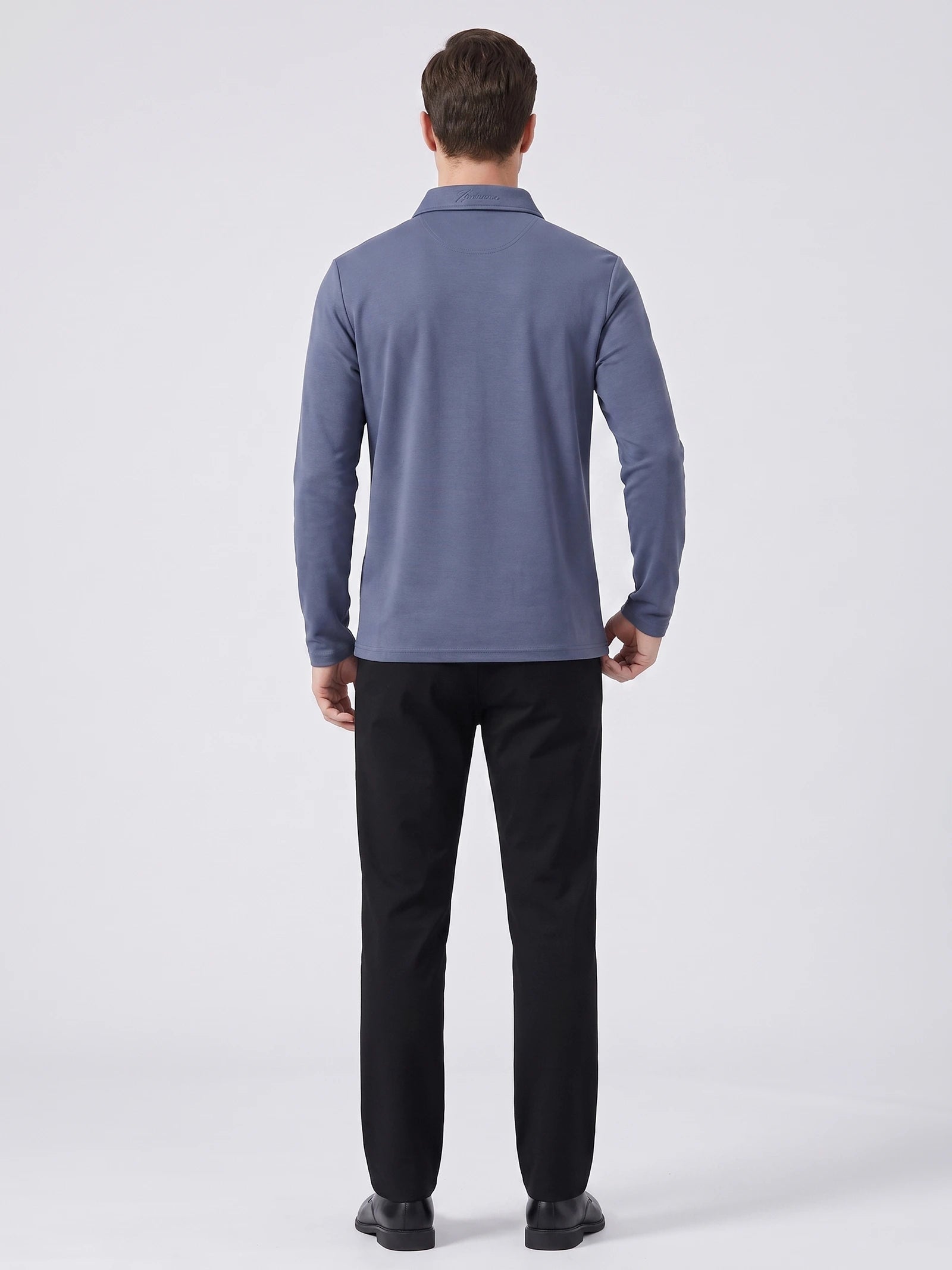 Back view of a model wearing a Blue long sleeve polo shirt with a structured collar.