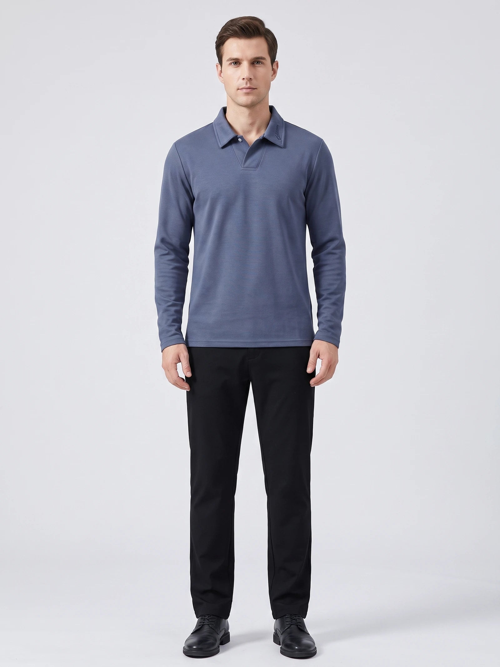 Front studio view of a model wearing a Blue long sleeve polo with an embroidered turn-down collar.