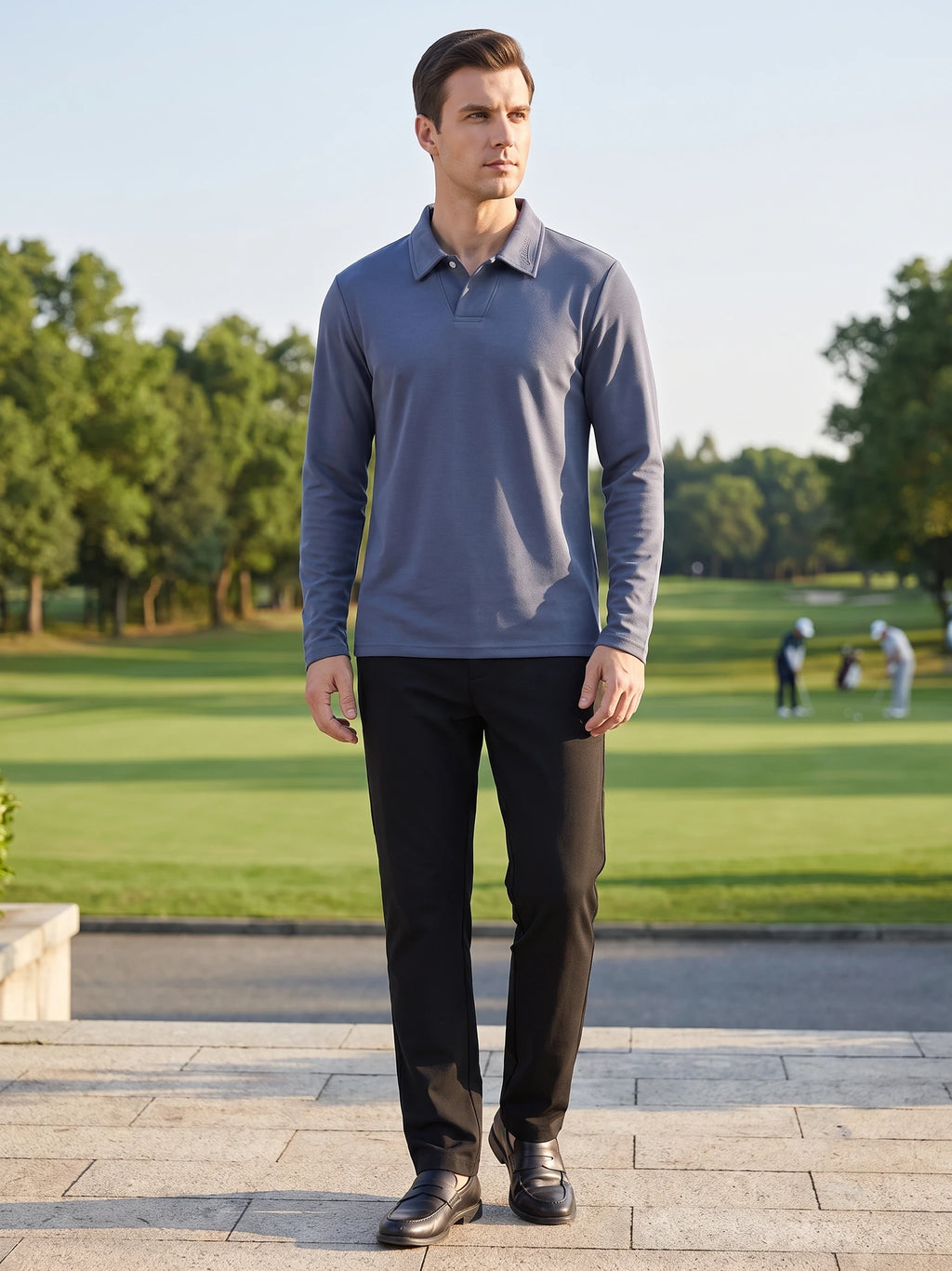 Model wearing a Blue long sleeve polo with an embroidered collar while walking beside a golf course.