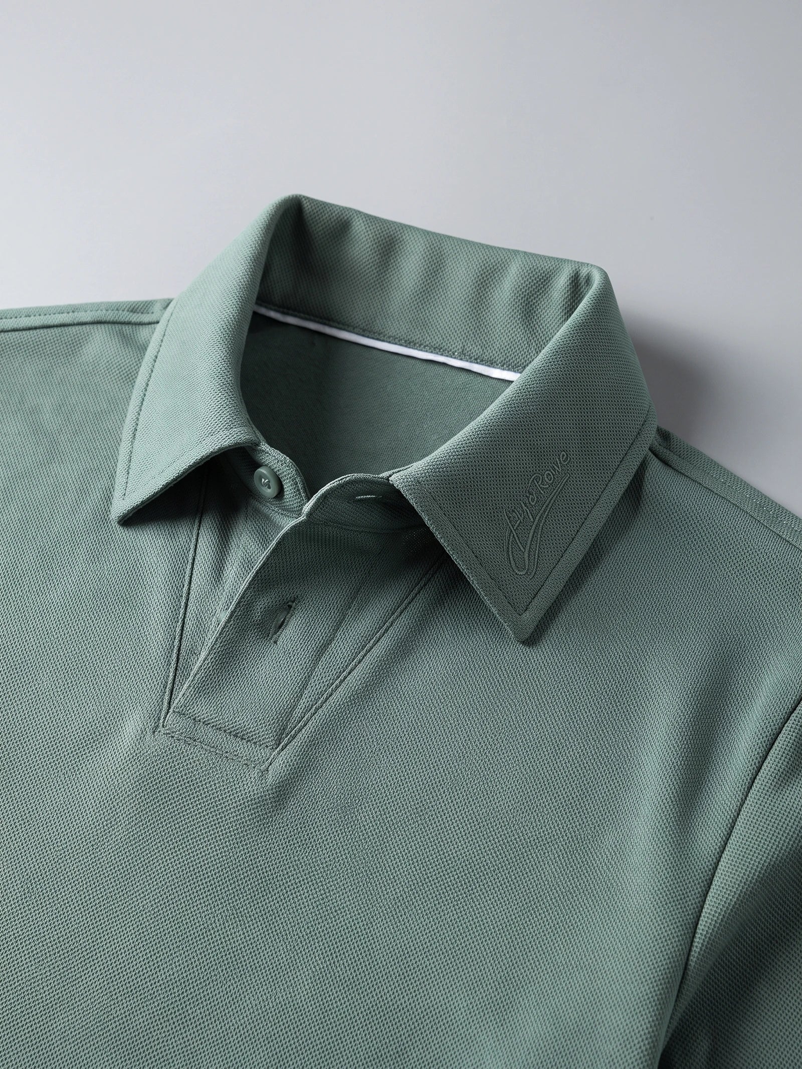 Close-up of a Green long sleeve polo shirt with textured knit fabric, button placket, and embroidered turn-down collar.