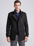 Front studio view of a model wearing a Black wool overcoat with a double-breasted button closure, wide lapels, and shoulder epaulets.