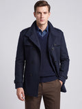 Front studio view of a model wearing a Navy wool overcoat with double-breasted buttons, wide lapels, shoulder tabs, and cuff straps.