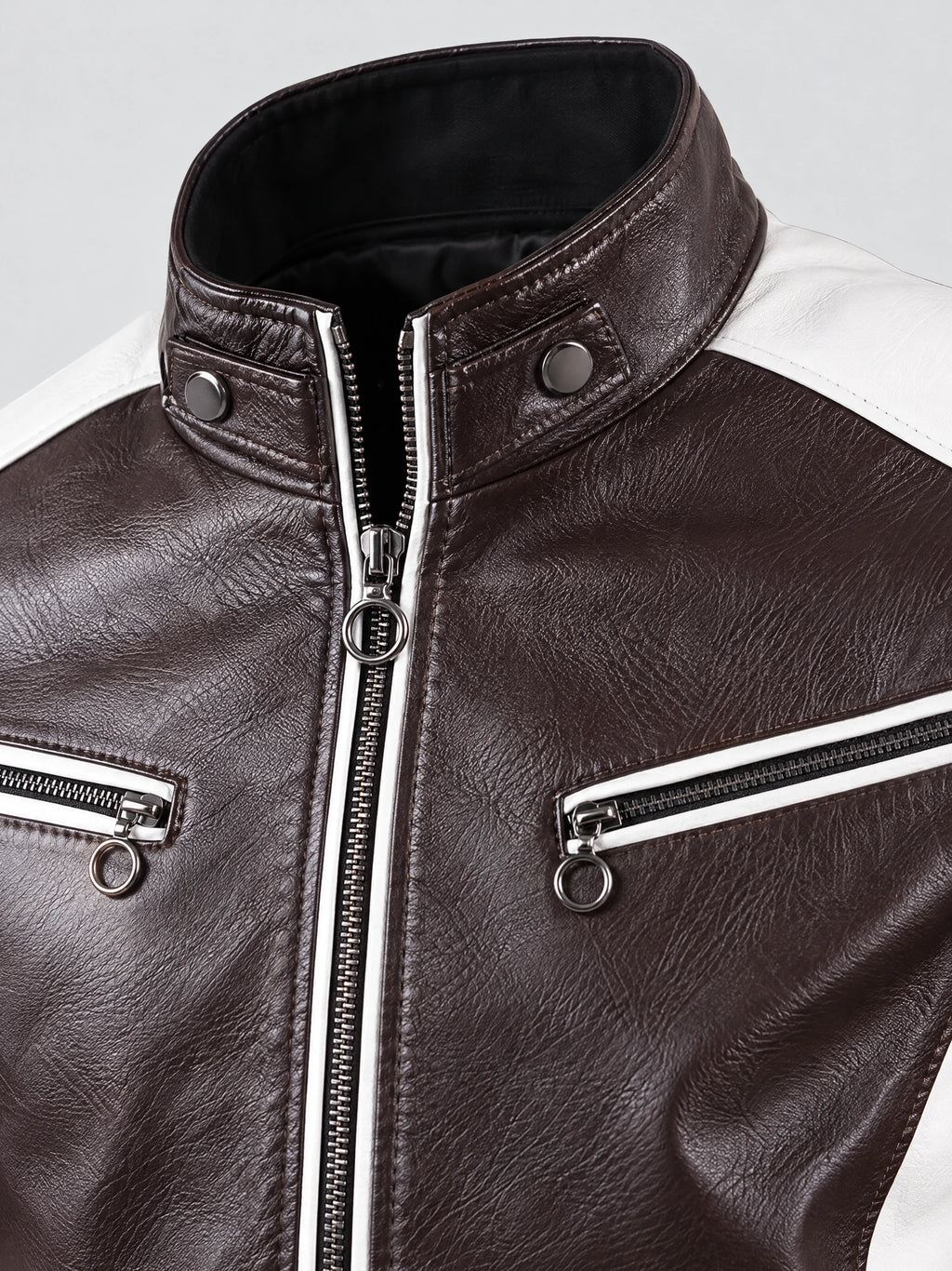 Close-up of the Brown Moto Leather Jacket’s stand collar, snap tabs, and ring-pull zippered chest pockets.