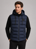 Front view of a man wearing a navy hooded puffer vest with cotton padding, thick insulation, sleeveless design, and full zip front