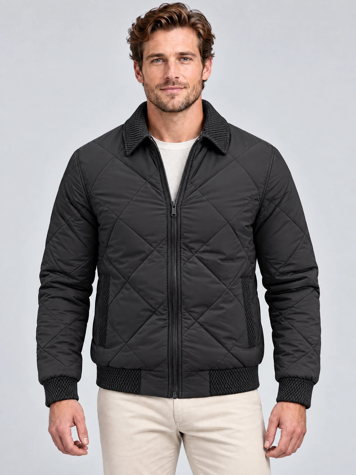 Front studio view of a model wearing a Black Men Padded Lapel Jacket with diamond quilting, zip closure, and textured collar and cuffs.