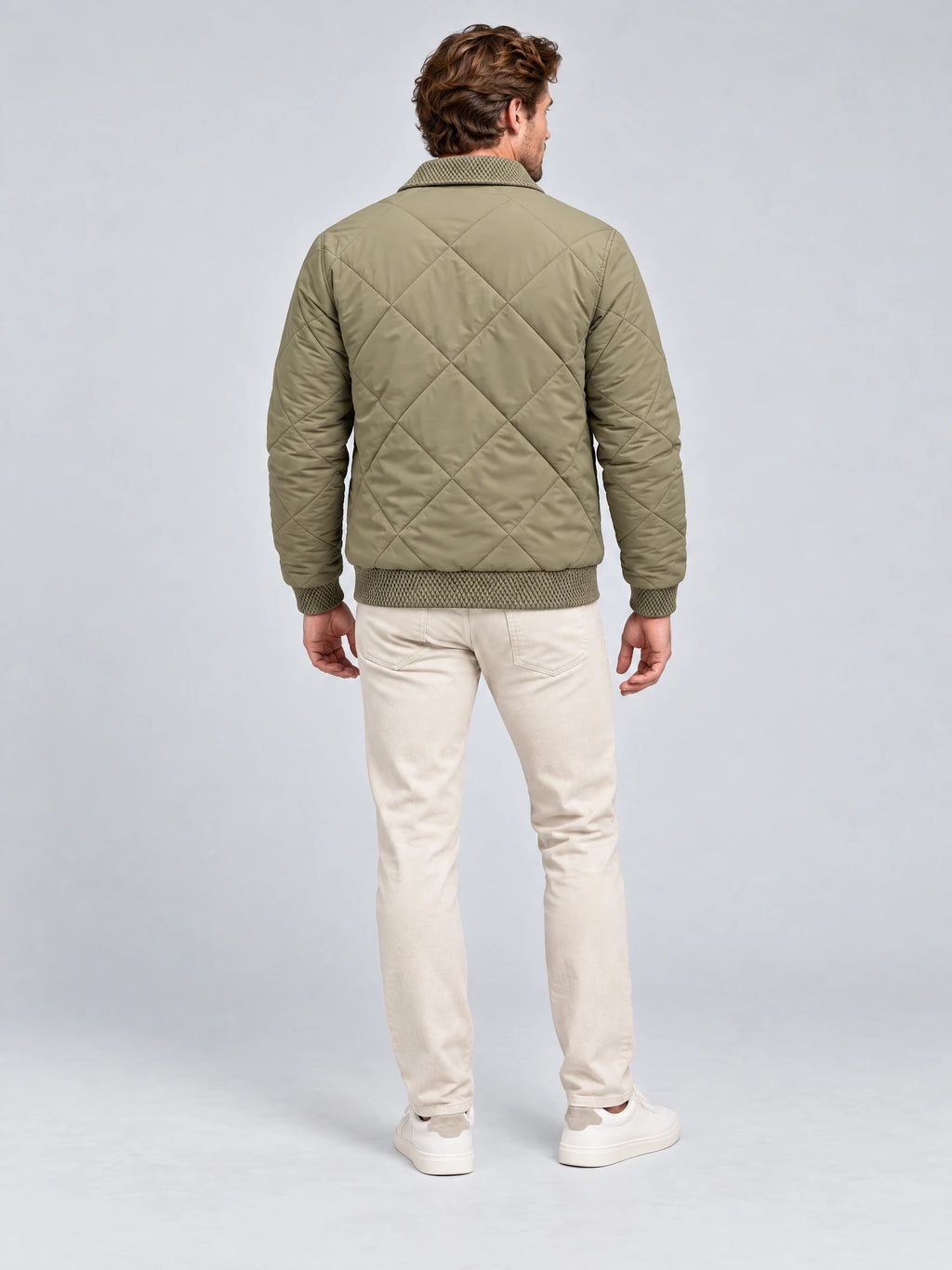 Rear studio view of a model wearing a Green men's padded lapel jacket with diamond quilting and ribbed trim.