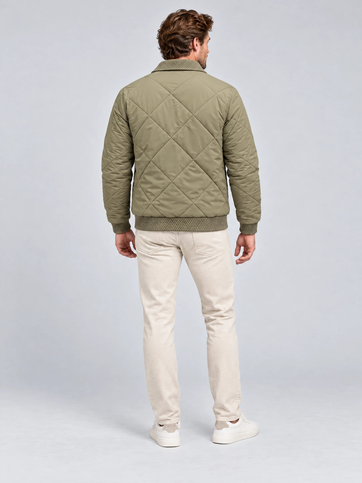 Rear studio view of a model wearing a Green men's padded lapel jacket with diamond quilting and ribbed trim.