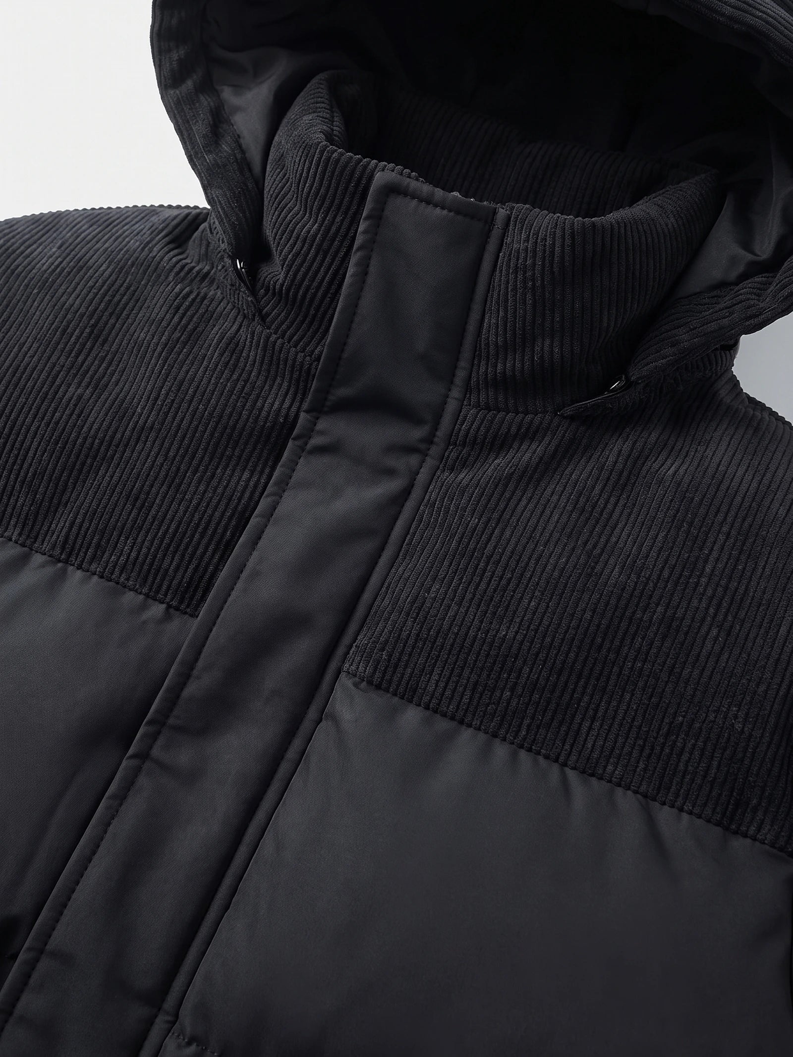 Close-up of the Black Padded Puffer Jacket showing the ribbed high collar, zipper placket, and quilted polyester panels.