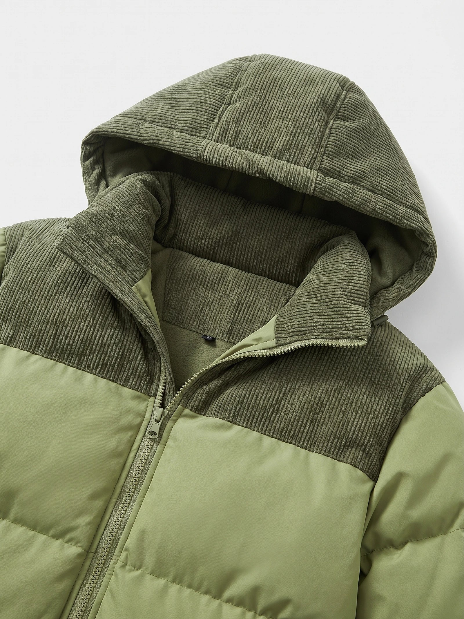 Green padded puffer jacket detail showing the ribbed hood, fleece lining, high collar, and front zipper.