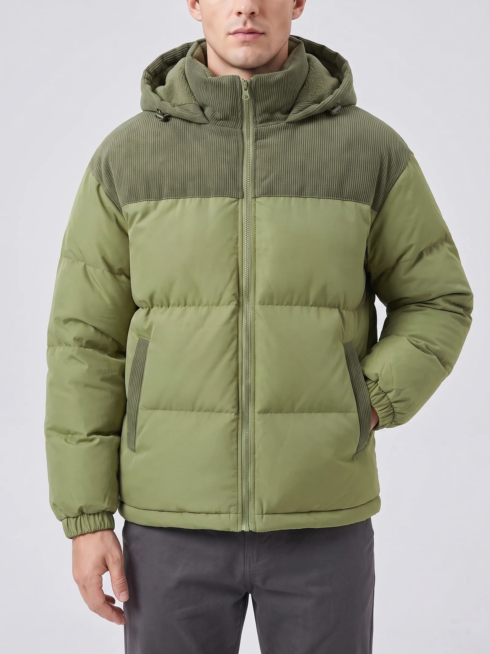 Front studio view of a model wearing a Green padded puffer jacket with a hood, ribbed upper panel, zip closure, and angled pockets.
