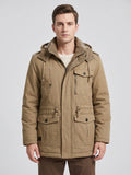 Front studio view of a model wearing a Khaki men's Parkas jacket with a hood, fleece-lined collar, zip front, and flap pockets.