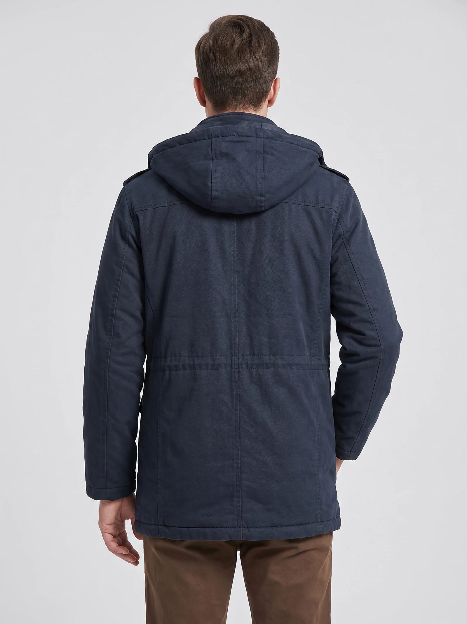 Back view of a model wearing a Navy men's Parkas jacket with a hood and stitched back paneling.