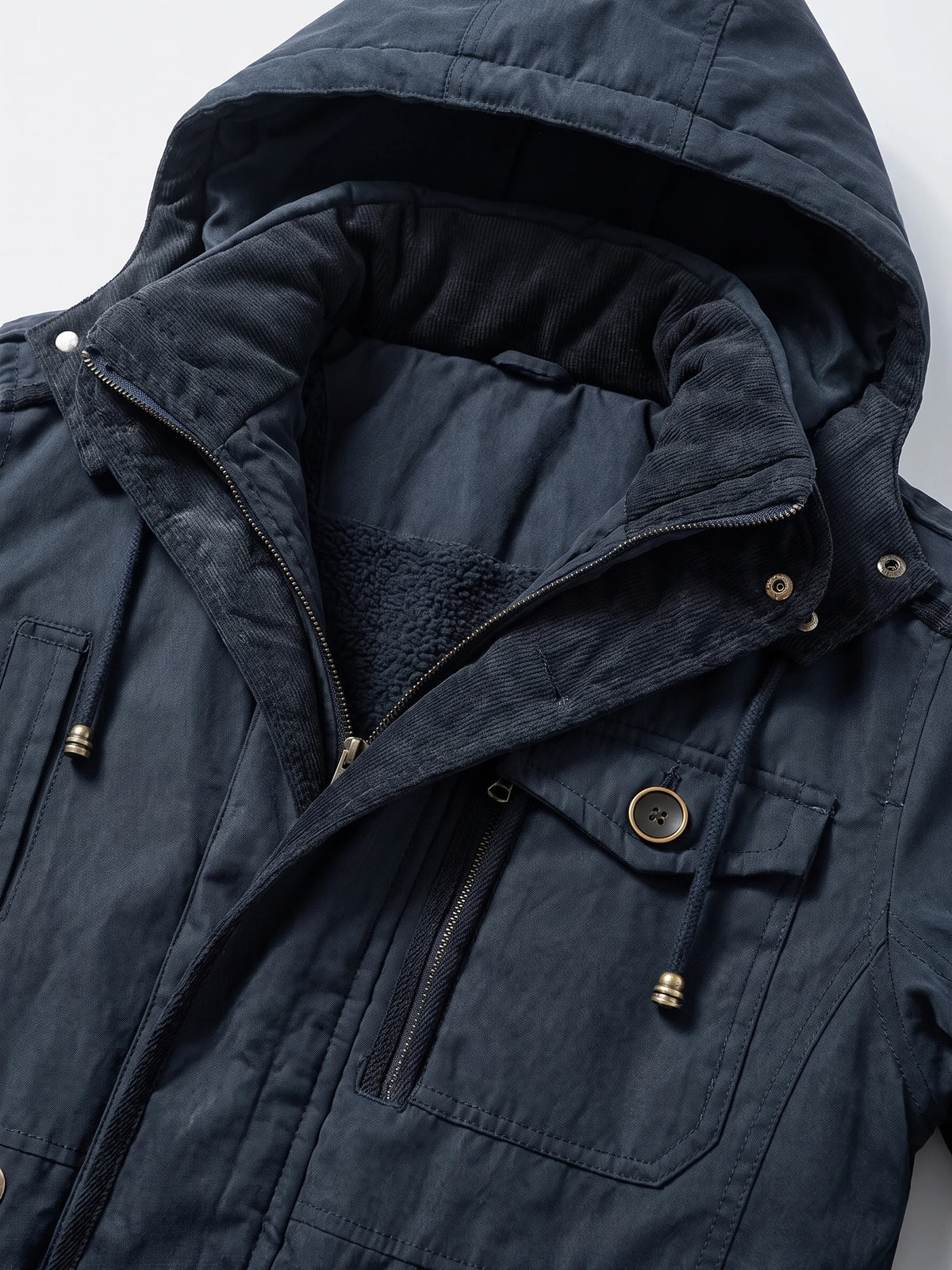 Navy men’s Parkas jacket detail showing the padded hood, ribbed inner collar, fleece lining, zipper, and flap pockets.