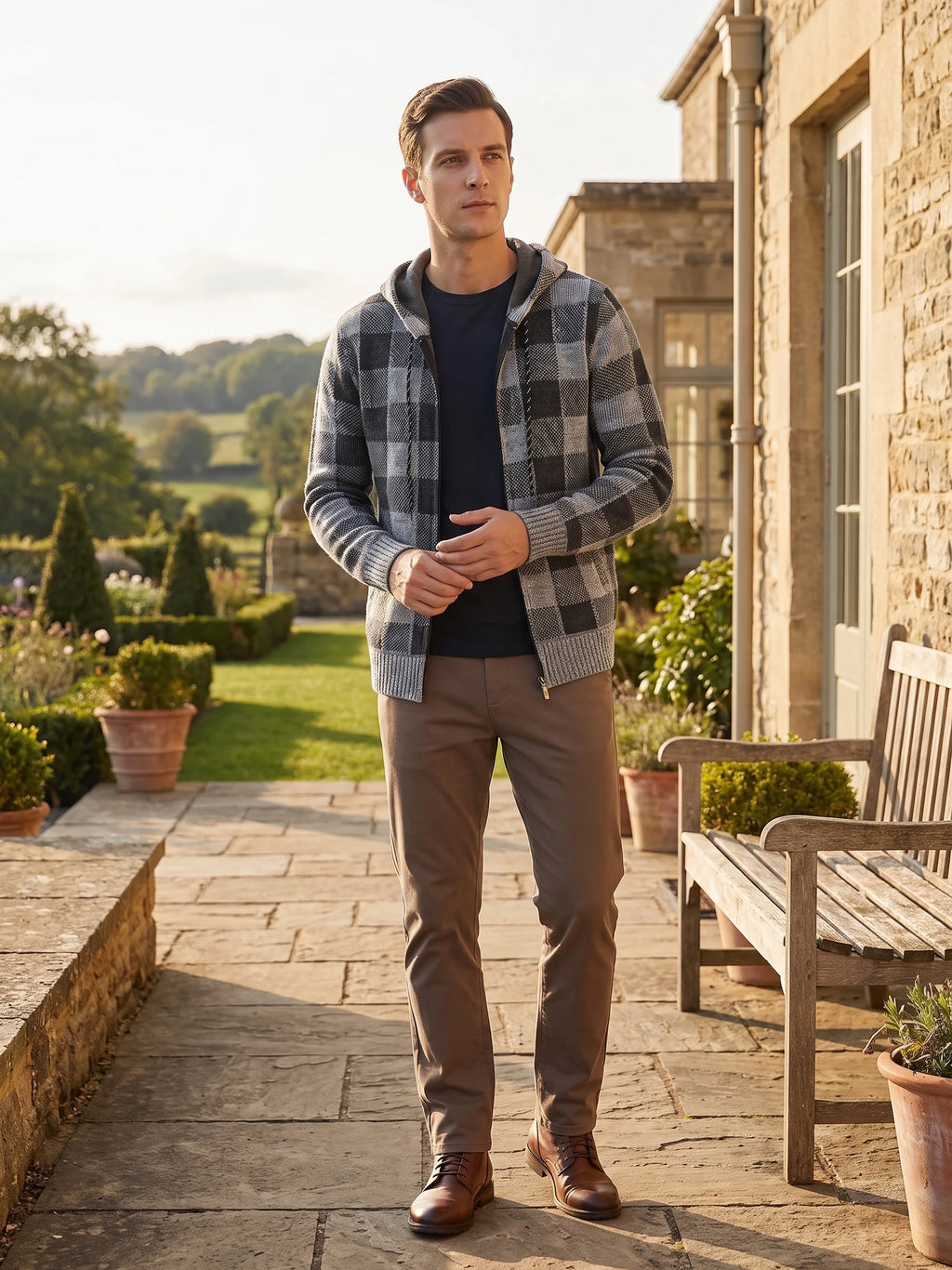 Man wearing a Gray Plaid Flannel hooded jacket on a stone garden path beside a house.