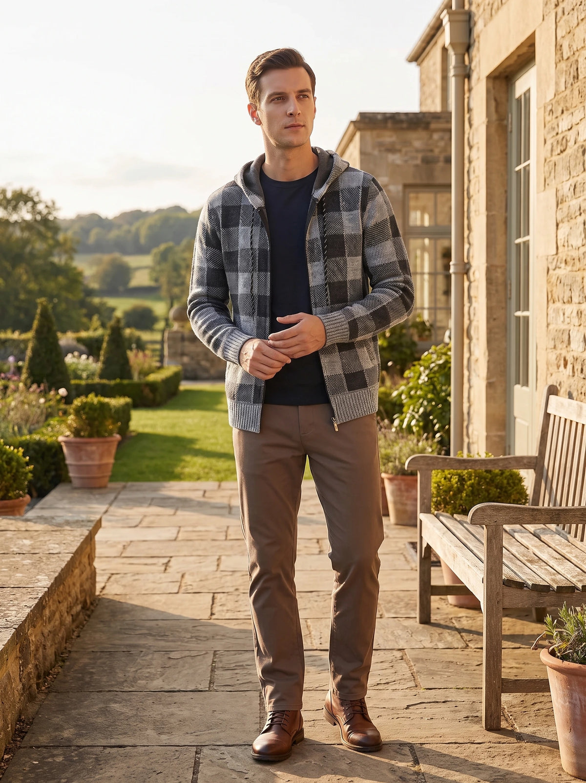 Man wearing a Gray Plaid Flannel hooded jacket on a stone garden path beside a house.