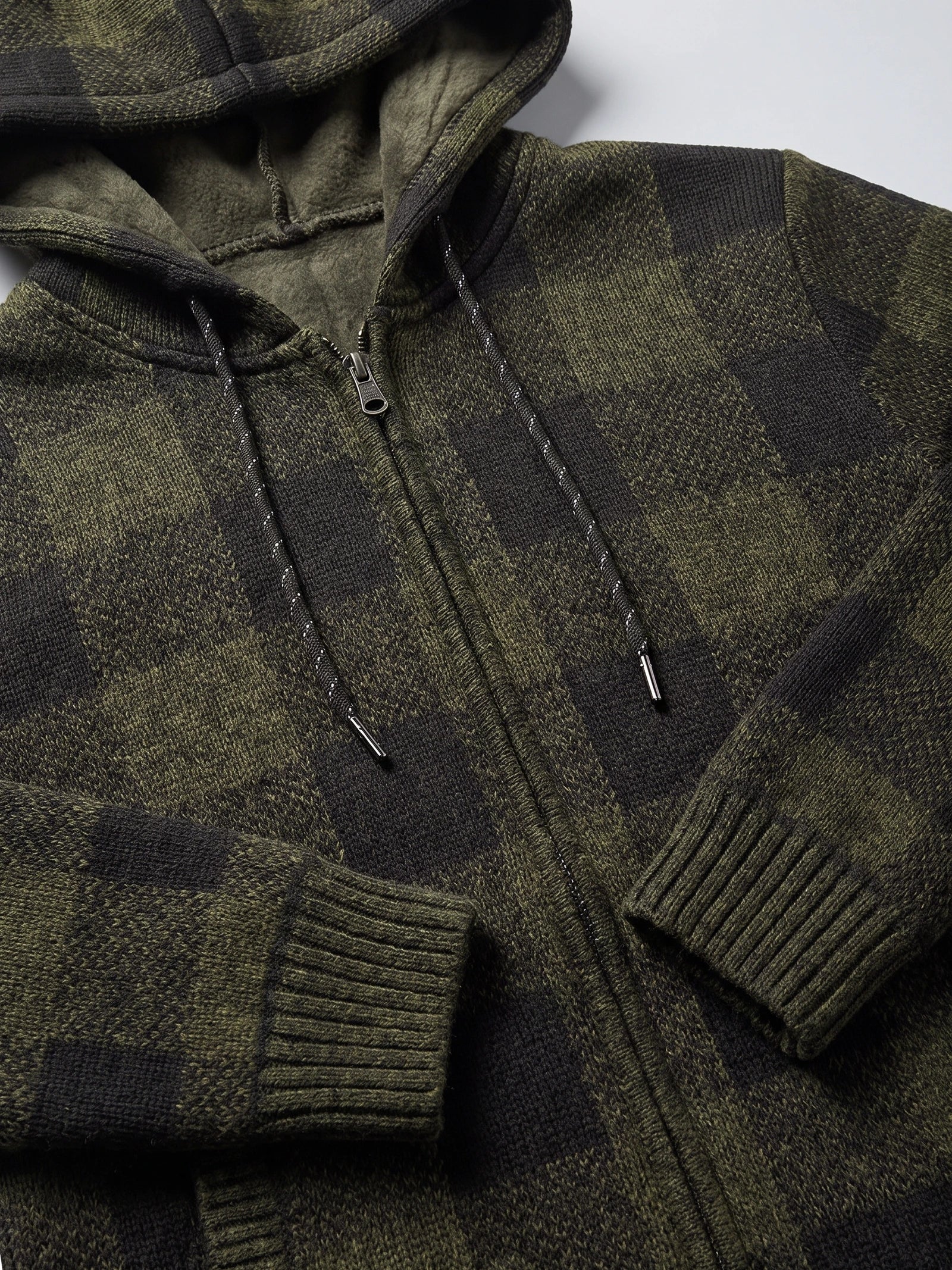 Green plaid flannel men’s hooded jacket detail showing the fleece-lined hood, front zipper, drawstrings, and ribbed cuffs.
