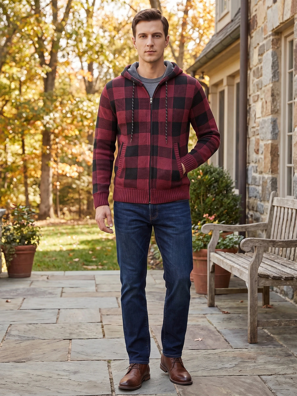 Model wearing a Wine Plaid Flannel hooded zip-front jacket on a stone patio beside a house and autumn trees.