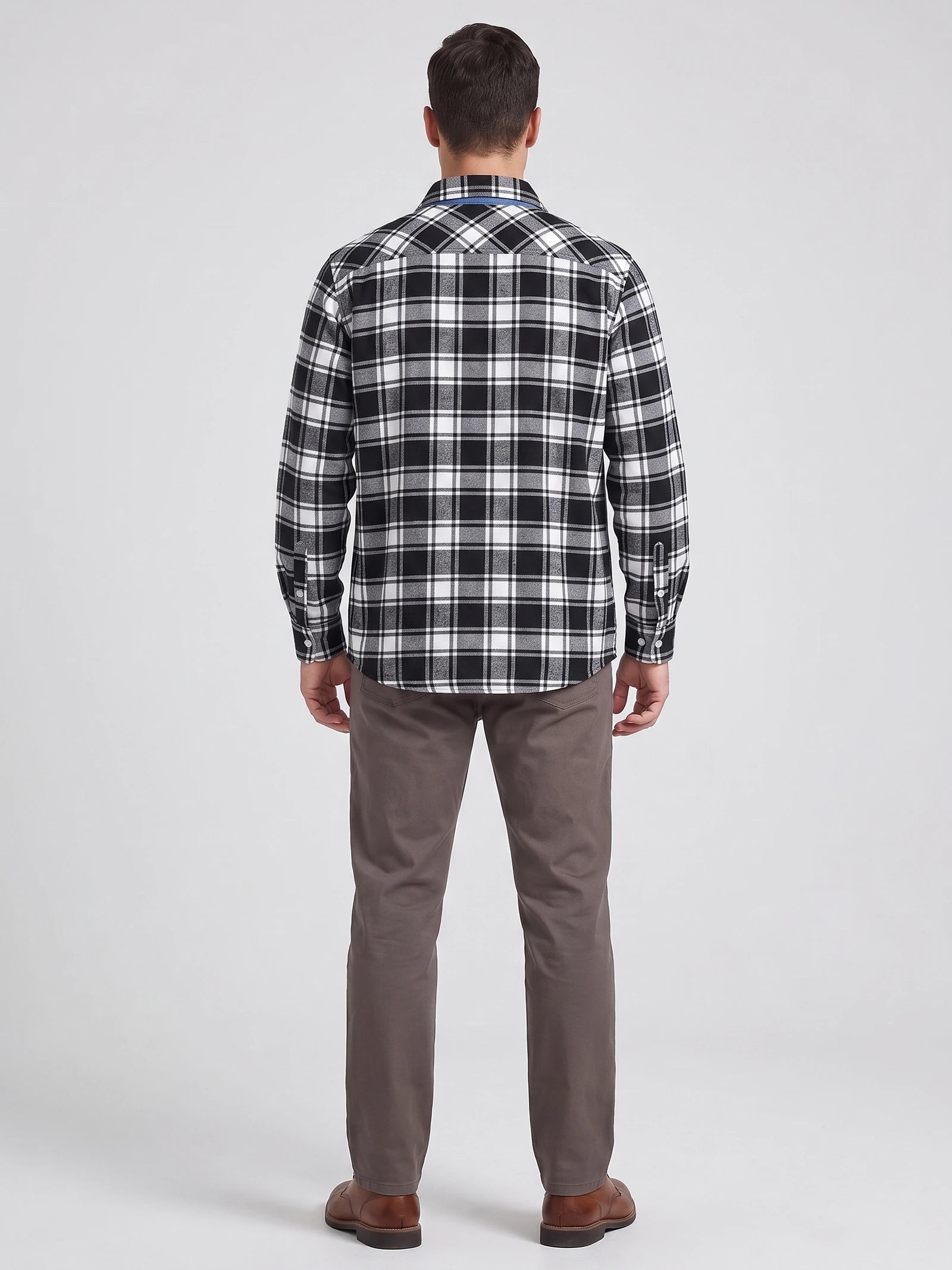 Rear studio view of a model wearing a Black plaid flannel shirt with long sleeves and button cuffs.