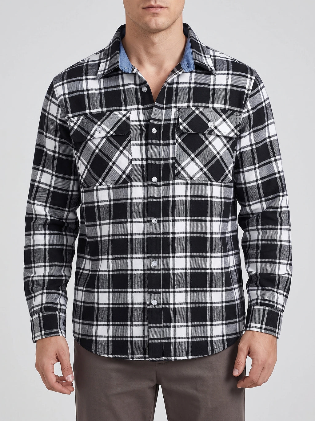 Front studio view of a model wearing a Black plaid flannel shirt with a button front, long sleeves, and two flap chest pockets.